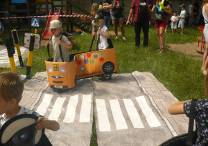 Przedszkolaki bawią się na makiecie ruchu drogowego